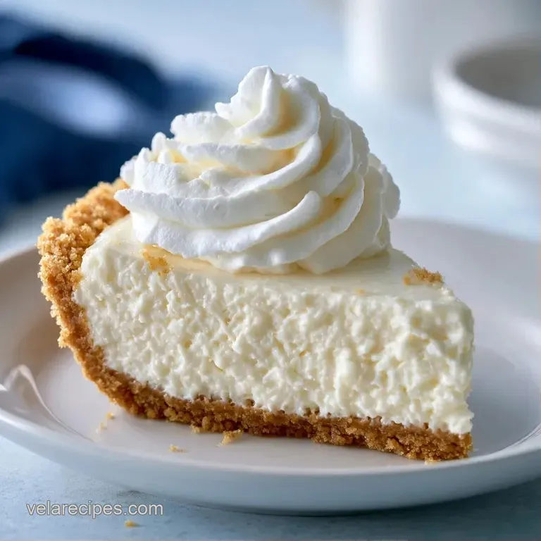 An elegant slice of white creamy dessert on a porcelain plate, garnished with a vibrant red raspberry and mint.